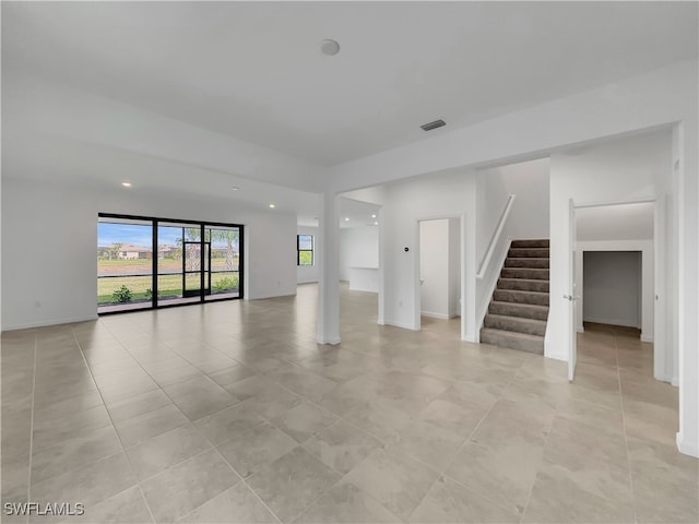 spare room with baseboards, stairs, visible vents, and light tile patterned flooring