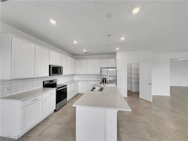 kitchen with decorative backsplash, a kitchen island with sink, stainless steel appliances, white cabinetry, and a sink