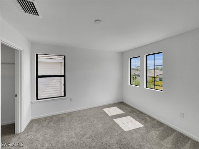 unfurnished bedroom featuring light colored carpet, visible vents, and baseboards