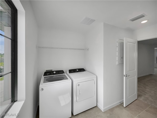 clothes washing area featuring laundry area, visible vents, washer and clothes dryer, and baseboards