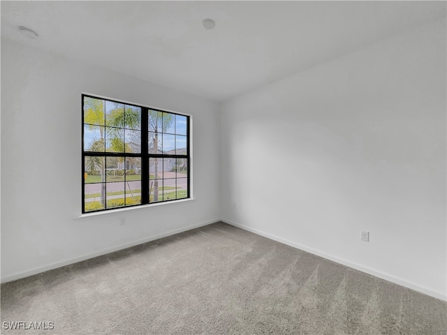 carpeted spare room with baseboards