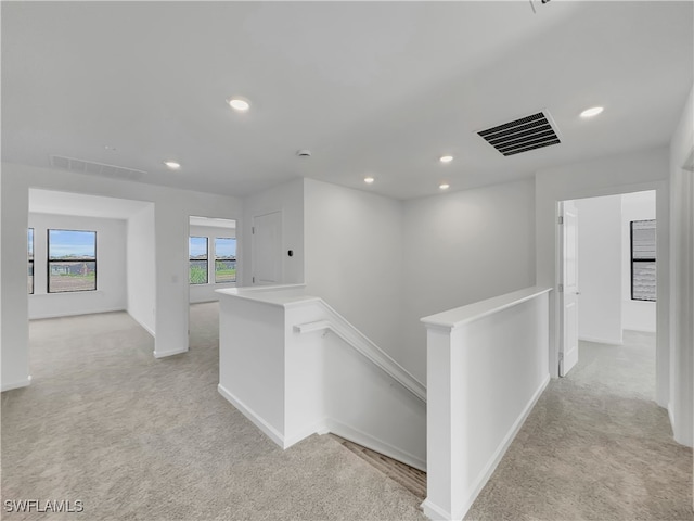 hall featuring recessed lighting, visible vents, light colored carpet, and an upstairs landing