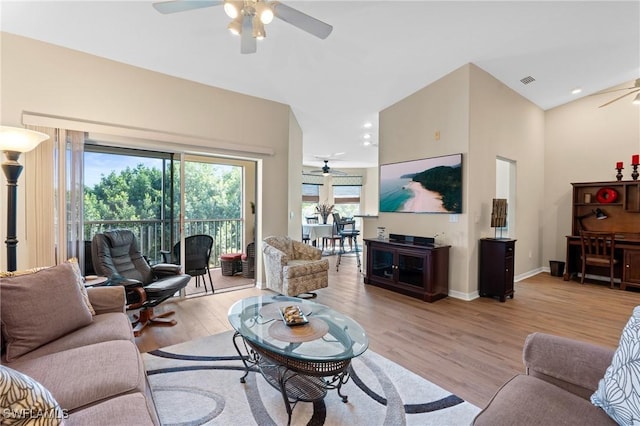 living area with vaulted ceiling, visible vents, a ceiling fan, and light wood-style floors