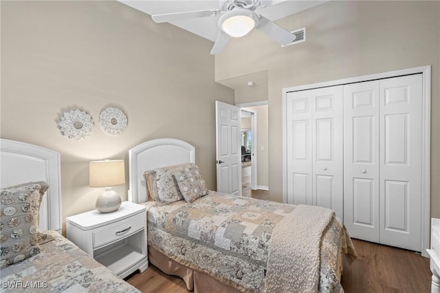 bedroom with ceiling fan, visible vents, a closet, and wood finished floors