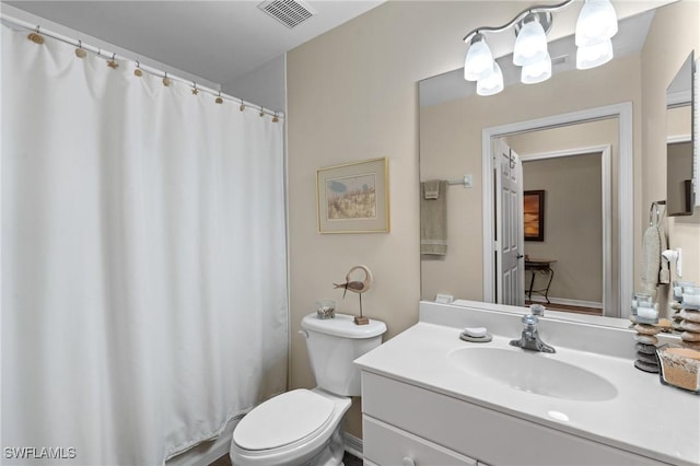 bathroom featuring toilet, vanity, visible vents, and a shower with curtain