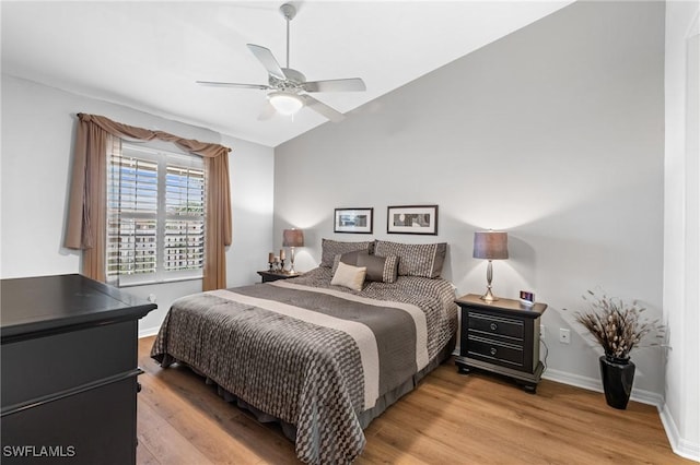 bedroom featuring lofted ceiling, ceiling fan, light wood-style flooring, and baseboards