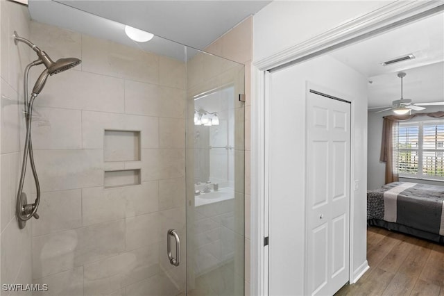 ensuite bathroom featuring ceiling fan, ensuite bathroom, wood finished floors, visible vents, and a stall shower