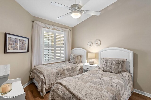 bedroom with lofted ceiling, dark wood-style flooring, ceiling fan, and baseboards