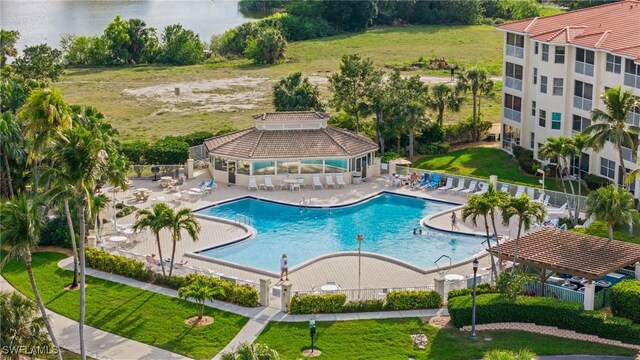 pool with a water view, fence, a gazebo, and a patio