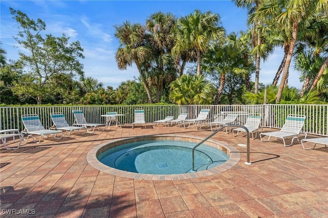 view of pool with a hot tub, fence, and a patio