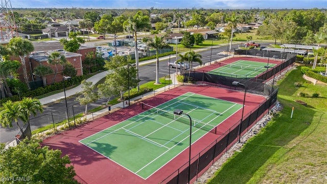 view of tennis court featuring a residential view and fence