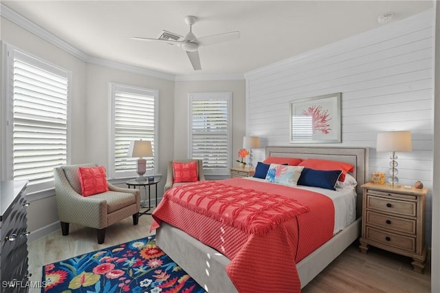 bedroom featuring visible vents, ornamental molding, wood finished floors, and a ceiling fan