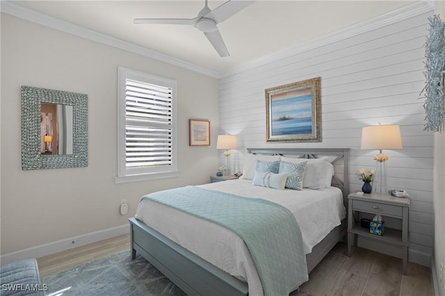 bedroom with a ceiling fan, crown molding, baseboards, and wood finished floors