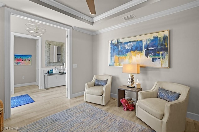 sitting room featuring baseboards, wood finished floors, visible vents, and crown molding