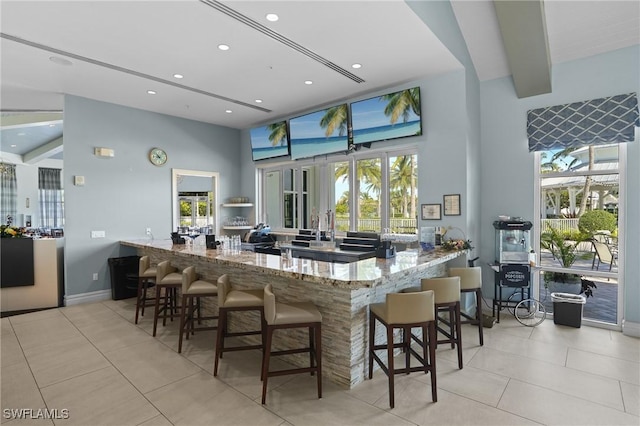 kitchen featuring stone countertops, tile patterned flooring, and a wealth of natural light