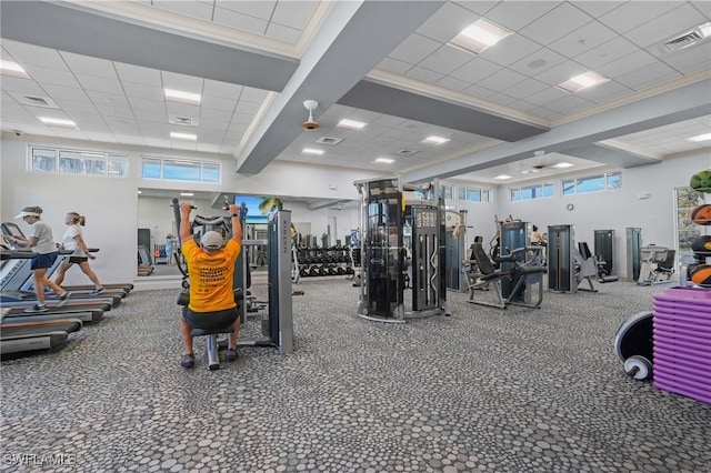 workout area with ornamental molding, a paneled ceiling, and visible vents