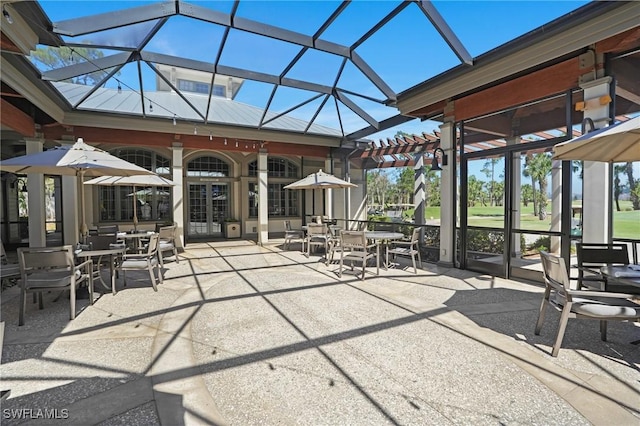 view of patio with outdoor dining area and a lanai