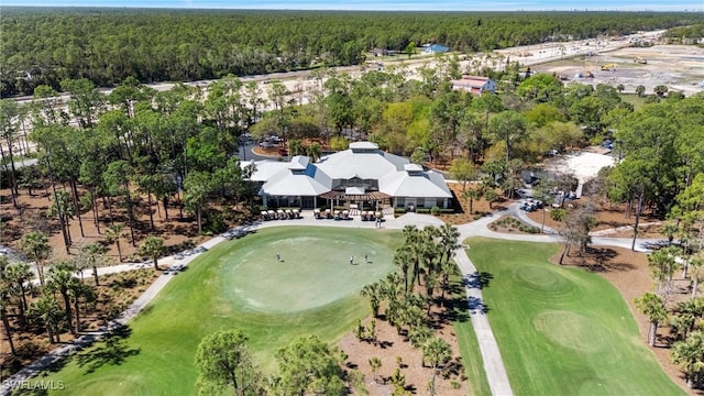 bird's eye view with view of golf course and a wooded view