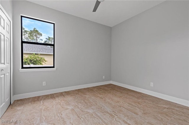 empty room featuring a ceiling fan and baseboards