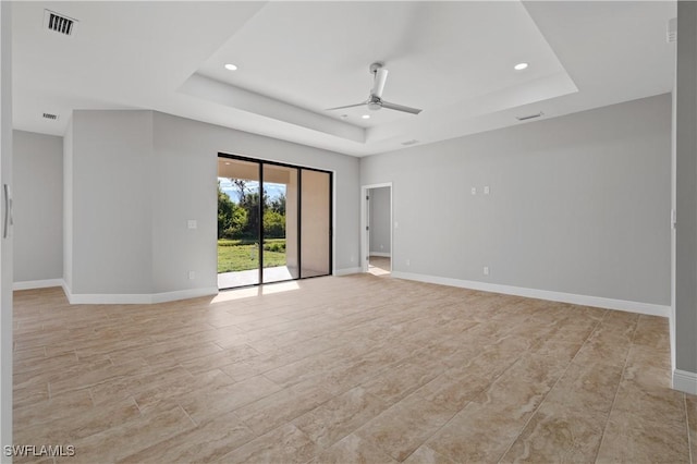 spare room with ceiling fan, a tray ceiling, baseboards, and recessed lighting