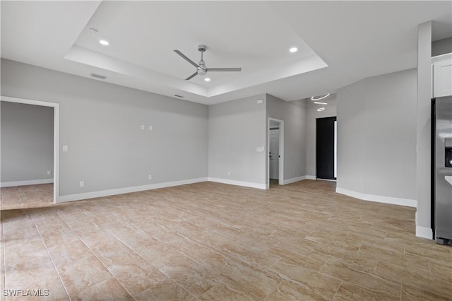 unfurnished room with ceiling fan, a tray ceiling, baseboards, and recessed lighting