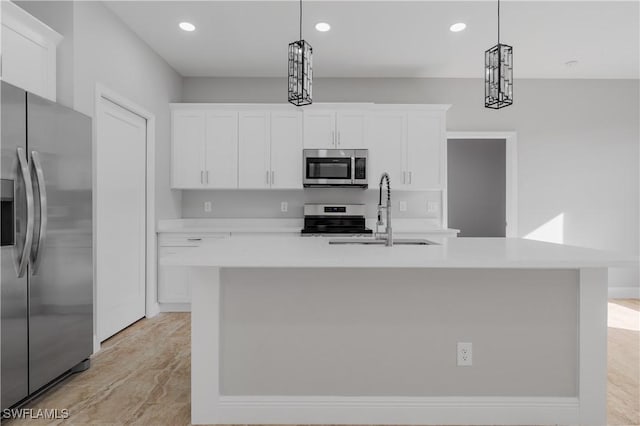 kitchen featuring a center island with sink, white cabinets, appliances with stainless steel finishes, pendant lighting, and a sink