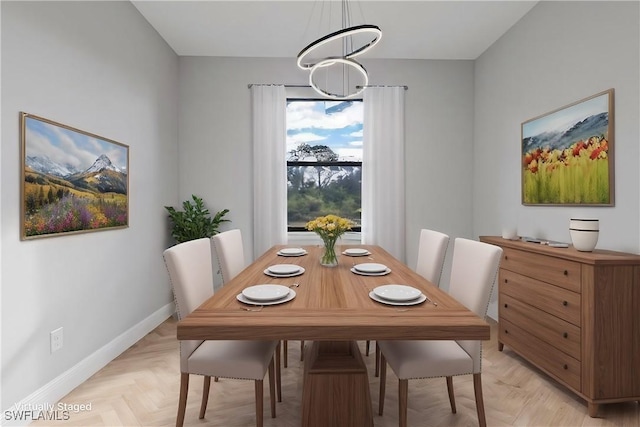 dining room featuring a chandelier and baseboards