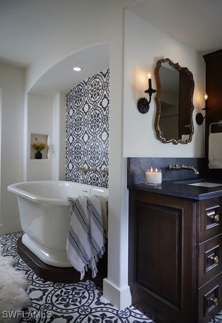 full bathroom featuring a freestanding tub and vanity