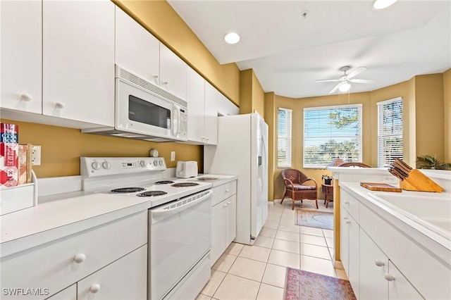 kitchen featuring white appliances, light tile patterned floors, light countertops, white cabinetry, and a sink