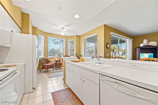 kitchen with light countertops, white appliances, white cabinets, and a sink