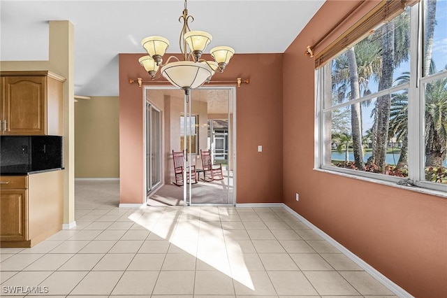 3266 Sturgeon Bay Ct, Naples, FL 34120 - unfurnished dining area with a chandelier, light tile patterned floors, and baseboards