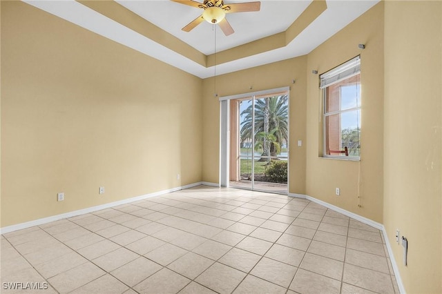 3266 Sturgeon Bay Ct, Naples, FL 34120 - spare room featuring ceiling fan, light tile patterned flooring, a raised ceiling, and baseboards