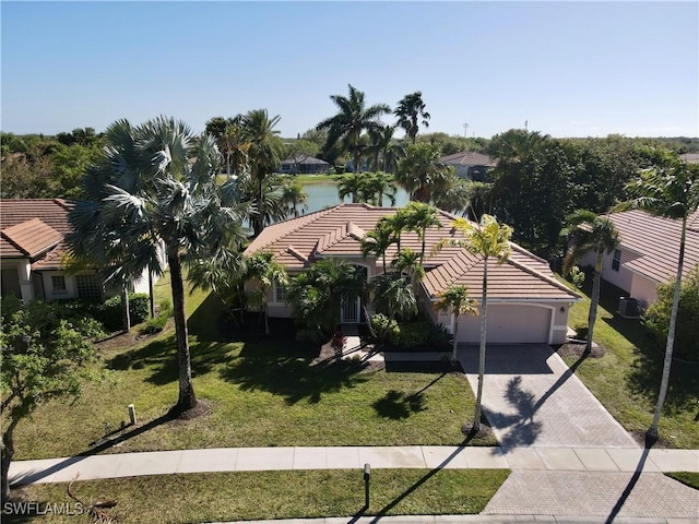 3266 Sturgeon Bay Ct, Naples, FL 34120 - view of front of home featuring cooling unit, a garage, a tiled roof, decorative driveway, and a front lawn