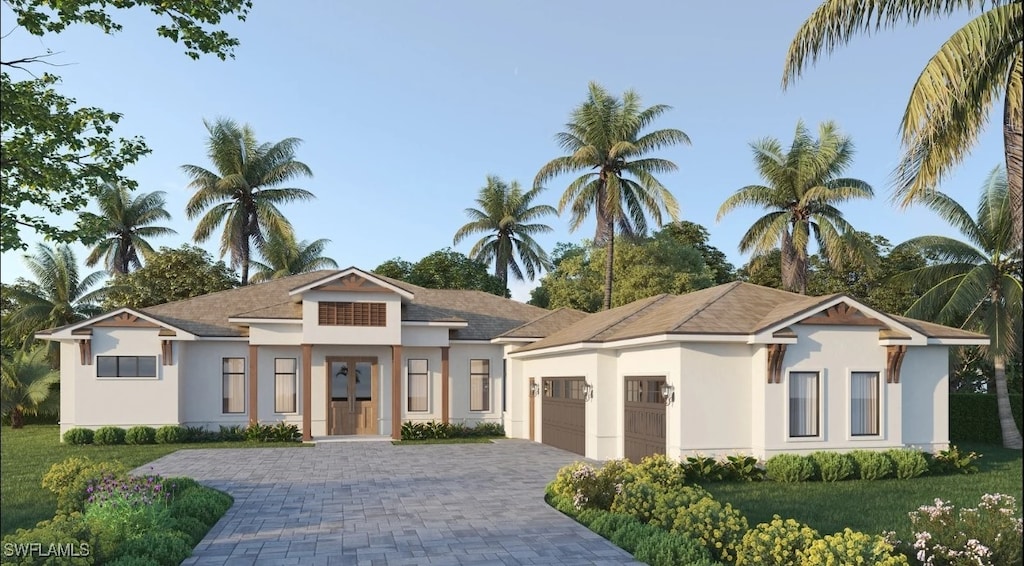 view of front of house with a garage, decorative driveway, a front yard, and stucco siding