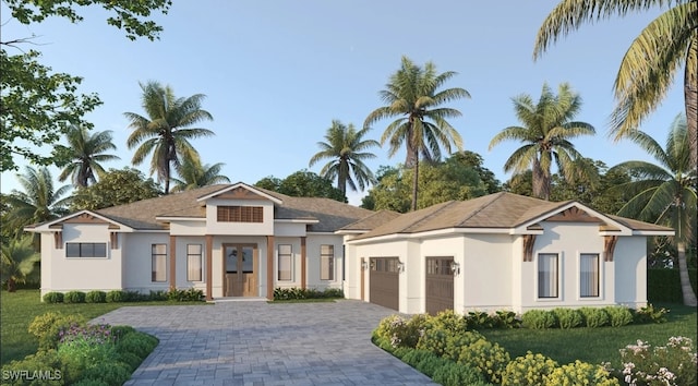 view of front of house with a garage, decorative driveway, a front yard, and stucco siding