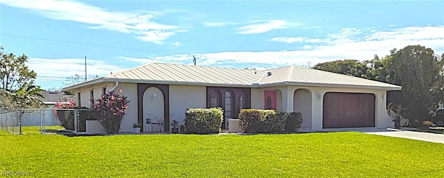 ranch-style house with a front yard, metal roof, concrete driveway, and stucco siding