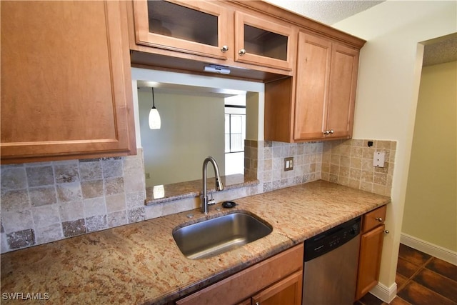 kitchen featuring dishwasher, light stone counters, a sink, and tasteful backsplash