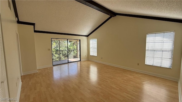 unfurnished room featuring vaulted ceiling with beams, light wood finished floors, a textured ceiling, and baseboards