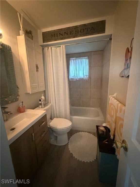 bathroom with toilet, wood finished floors, shower / bath combination with curtain, and vanity