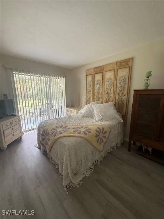 bedroom with access to outside and wood finished floors