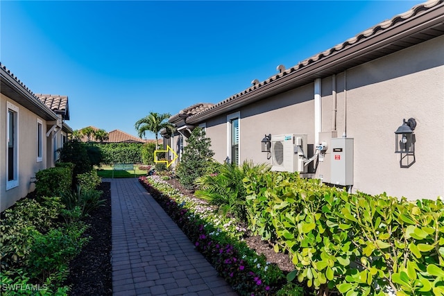 view of side of property featuring a tiled roof and stucco siding