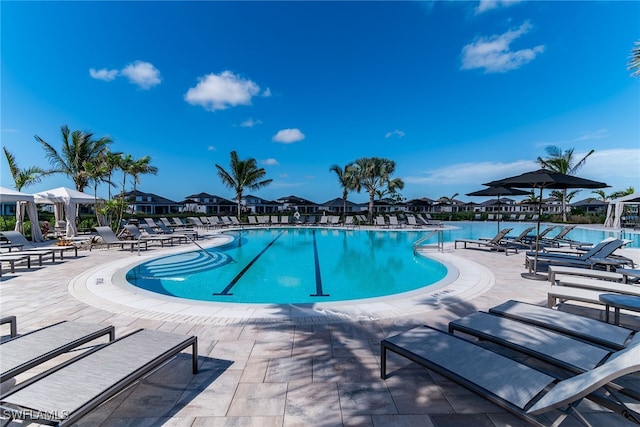 community pool with a residential view and a patio area