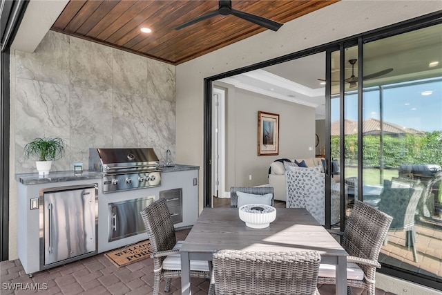 view of patio / terrace with a grill, a ceiling fan, exterior kitchen, and outdoor dining space