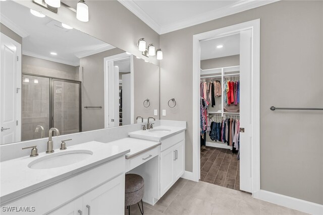 full bath featuring a shower stall, a spacious closet, ornamental molding, and a sink