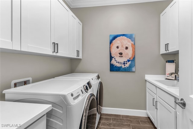 laundry room with cabinet space, ornamental molding, a sink, separate washer and dryer, and baseboards