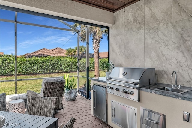 view of patio with exterior kitchen, a lanai, a sink, and grilling area