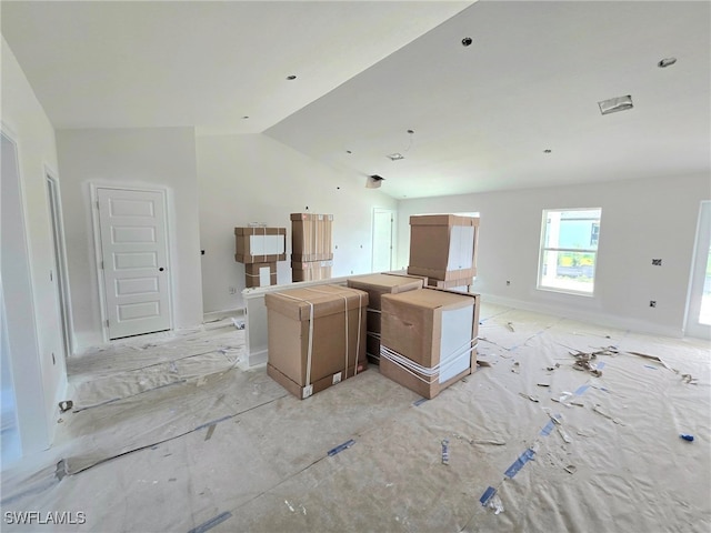 kitchen featuring baseboards, vaulted ceiling, and open floor plan