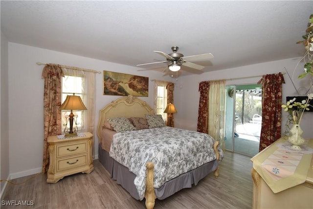 bedroom with access to exterior, baseboards, light wood finished floors, and a ceiling fan