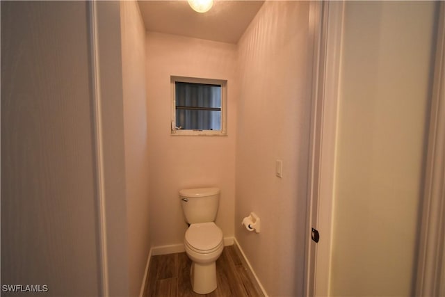 bathroom featuring toilet, baseboards, and wood finished floors