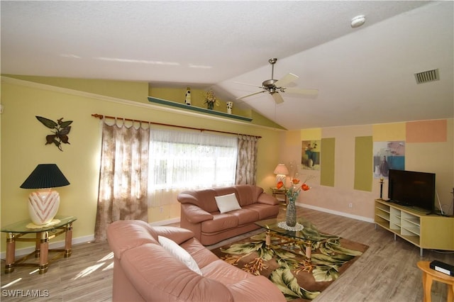 living area with baseboards, visible vents, ceiling fan, wood finished floors, and vaulted ceiling